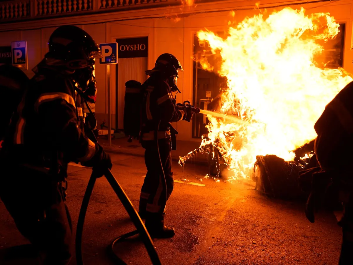 Іспанія - Демонстрації проти амністії Пожежникам доводиться гасити контейнер для сміття, підпалений демонстрантами.