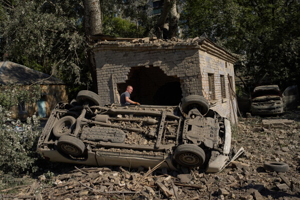 Місцевий житель стоїть біля зруйнованих автомобілів після нічної атаки російських ракет і безпілотників, Київ, Україна, четвер, 20 серпня 2026 р. (AP Photo/Francisco Seco)